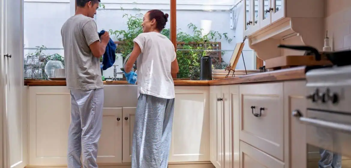 Pasangan suami istri sedang mencuci piring