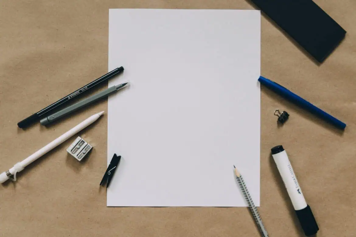 Kertas dengan alat tulis di sekitarnya