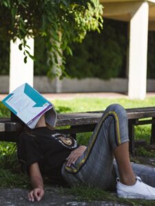 Seseorang menutup muka dengan buku