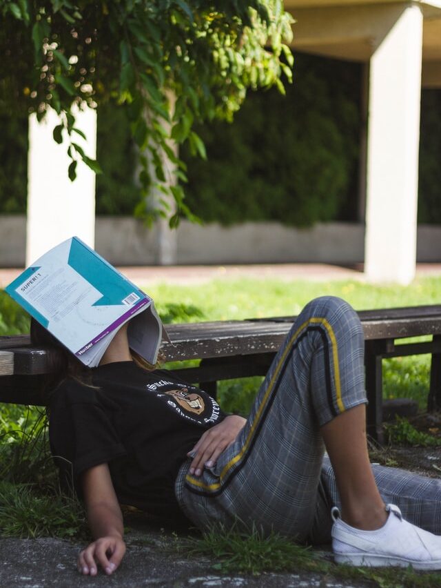 Seseorang menutup muka dengan buku