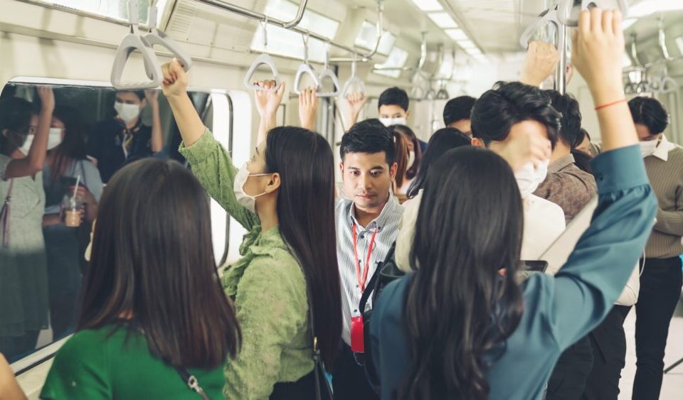 Crowd of people wearing face mask on a crowded public subway train travel . Coronavirus disease or COVID 19 pandemic outbreak and urban lifestyle problem in rush hour concept .