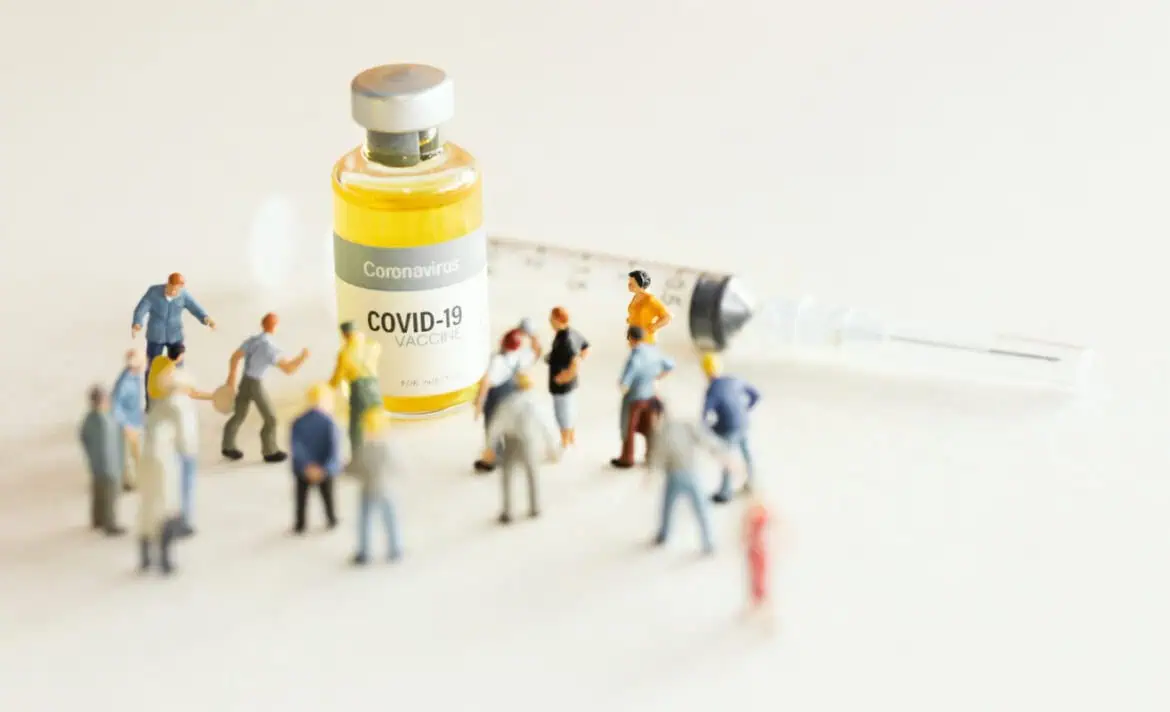 Ilustrasi miniatur kerumunan di sekitar botol vaksin