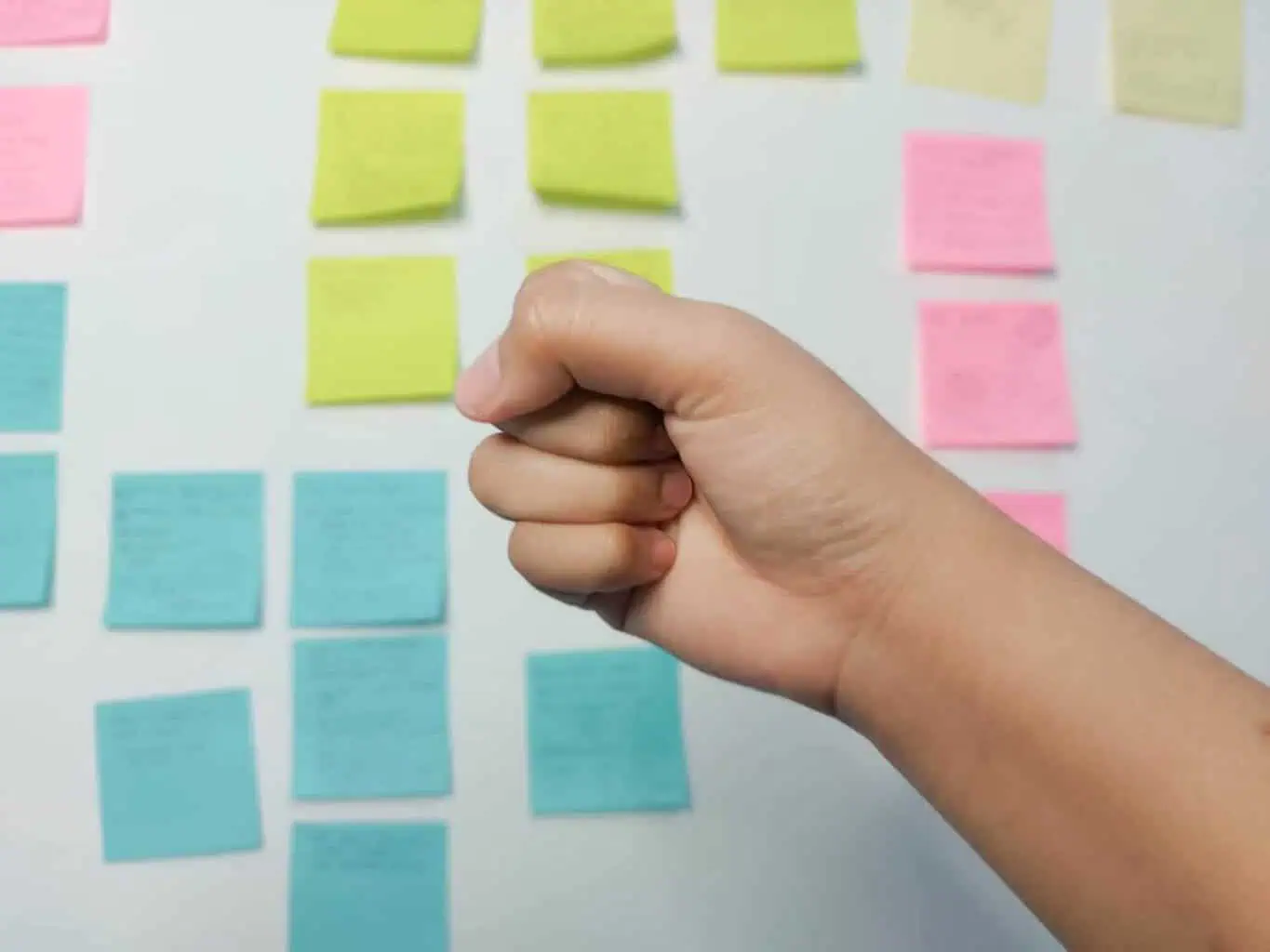 Tangan menggenggam dengan latar post-it