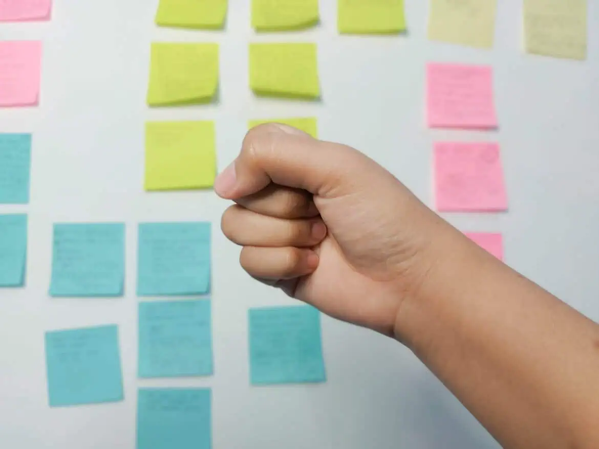 Tangan menggenggam dengan latar post-it